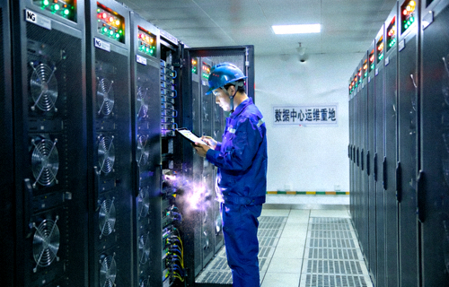 NG电子游戏数据中心机房内整齐排列的服务器机柜与运维工程师